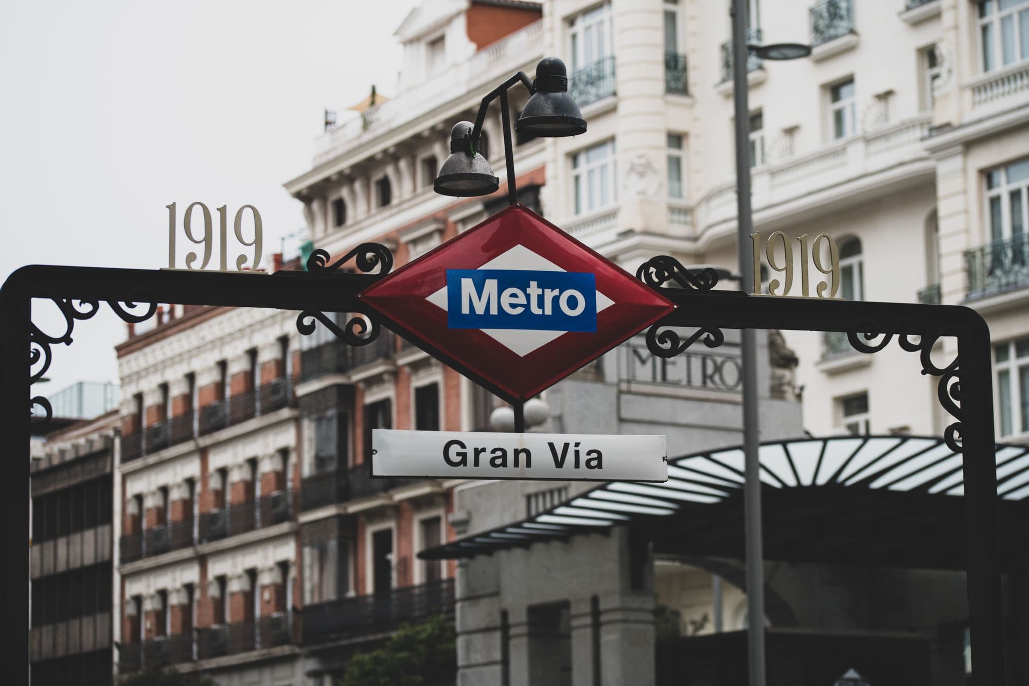 The classic red Madrid Metro sign stands above a Gran Vía entrance.