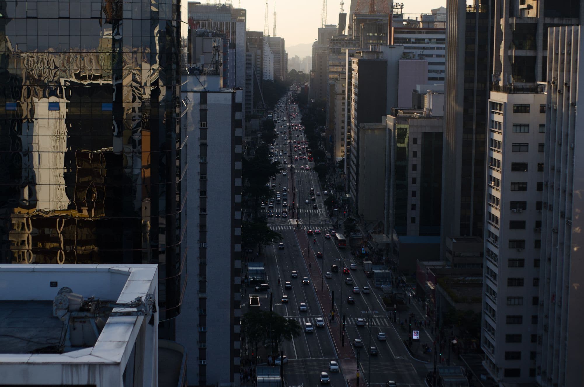 Avenida Paulista towers reflecting the blue and orange light of early evening.