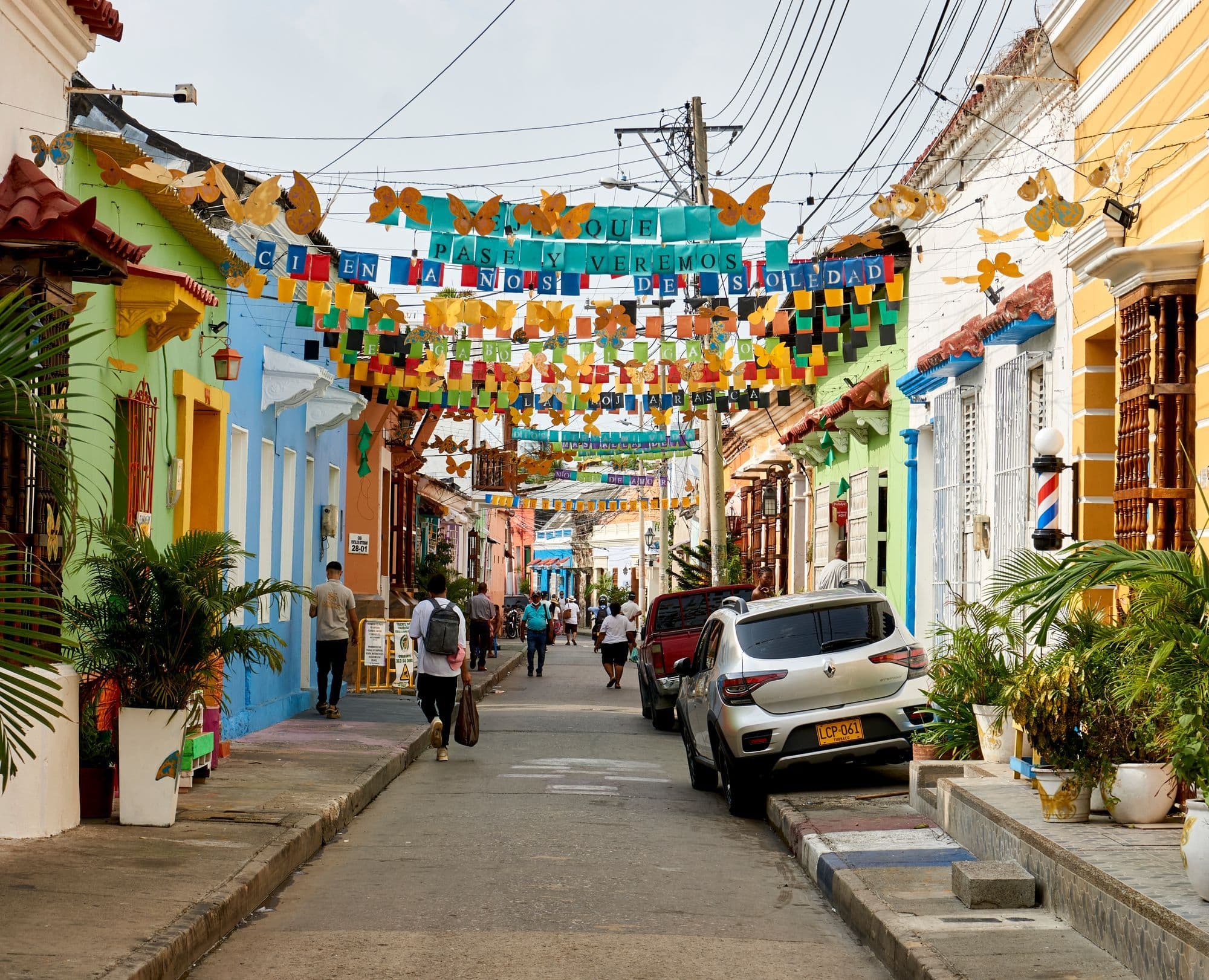 A colourful street in Getsemaní, Cartagena, with painted houses and strings of bright decorations overhead.