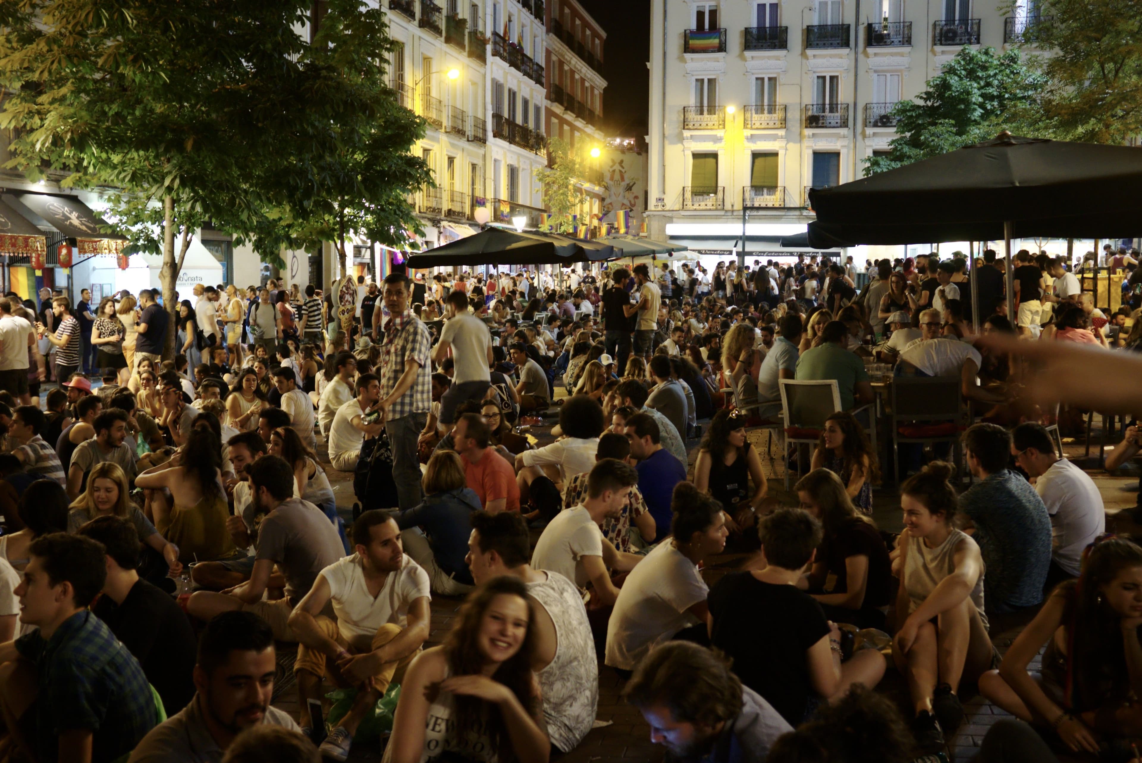 Crowds and rainbow flags fill the Plaza de Chueca in Madrid during Pride week.