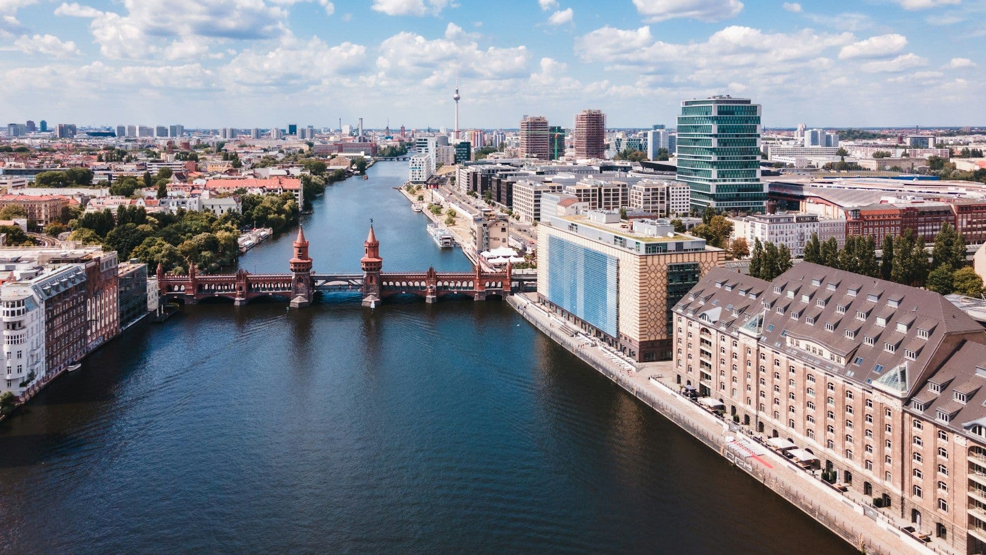 The Spree passing modern buildings on a clear day in central Berlin.