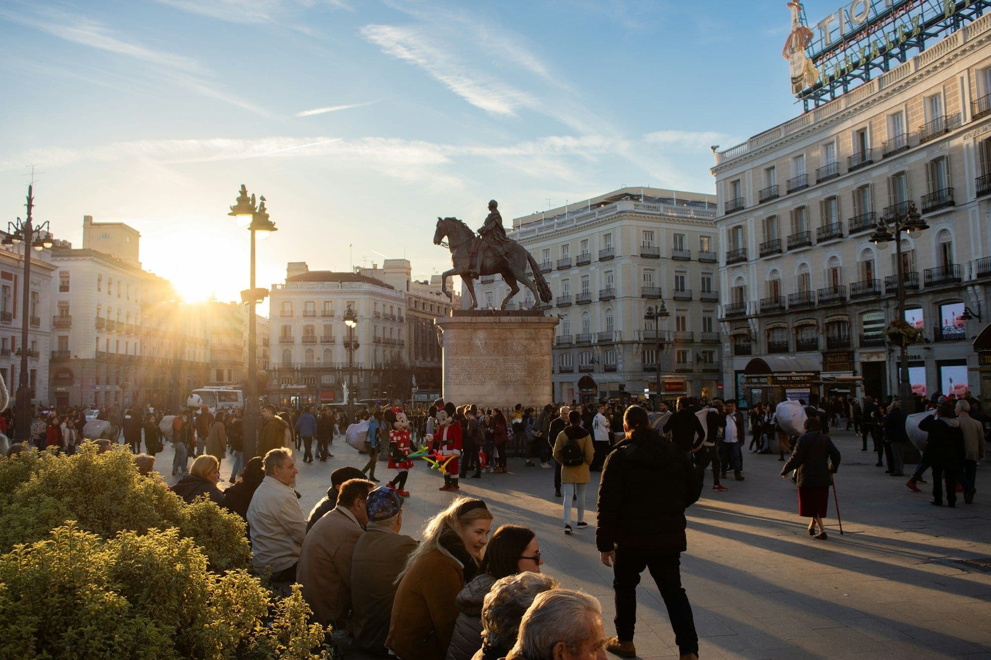 Pedestrians walking through a busy central Madrid street.