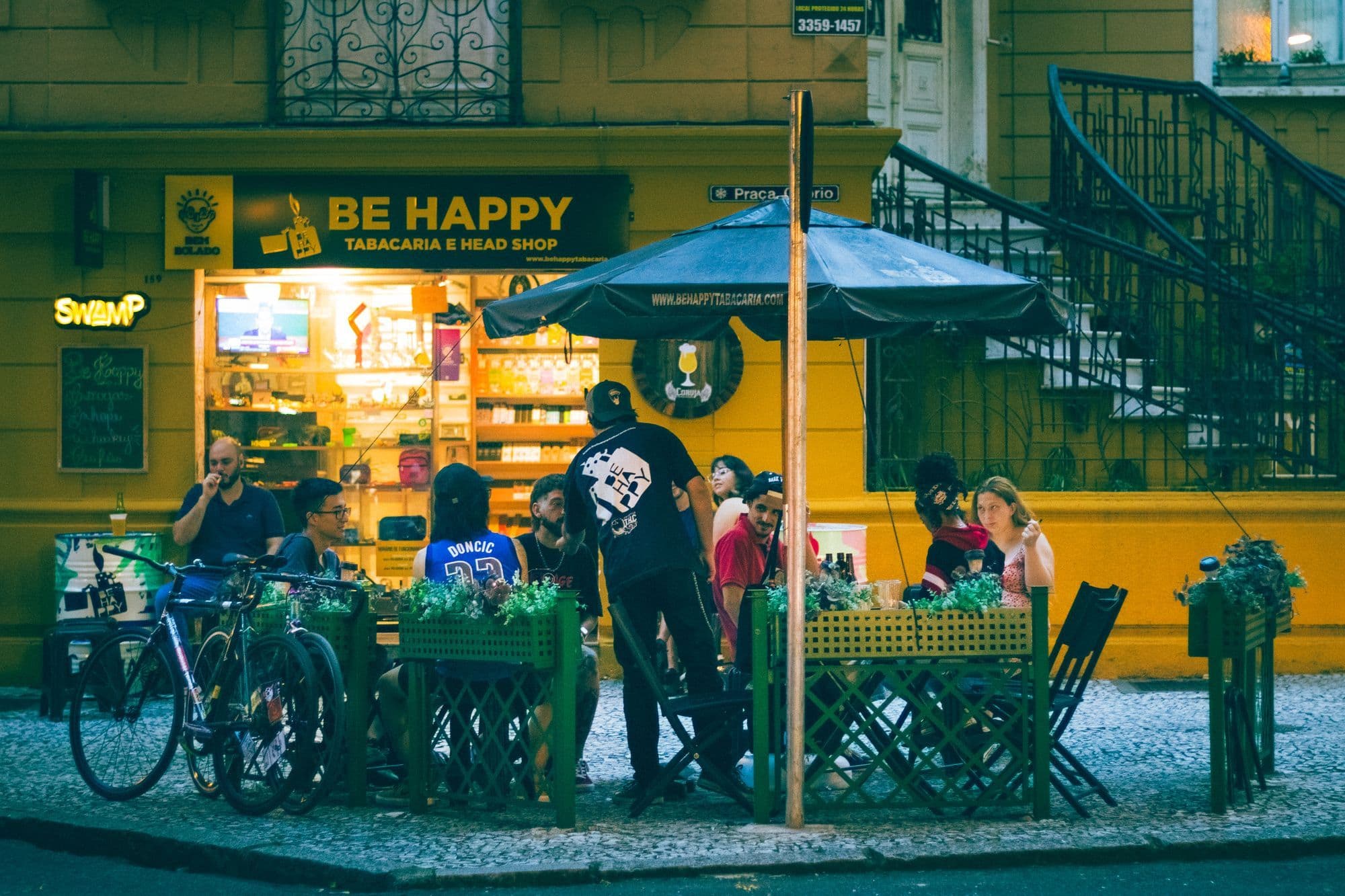 People sit and talk together at an urban bar after dark.