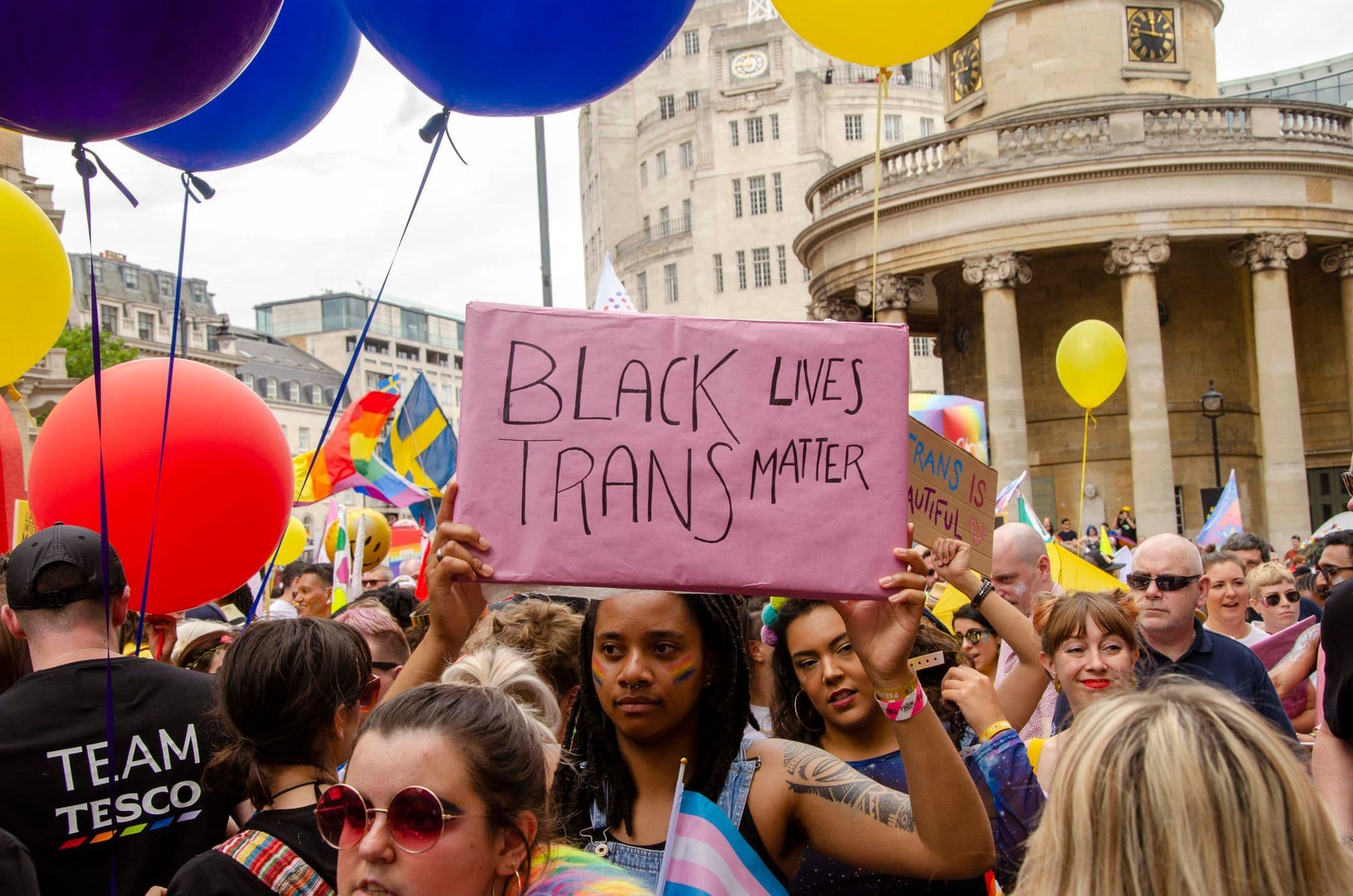 Pride marchers carrying equality signs and rainbow flags through central London.