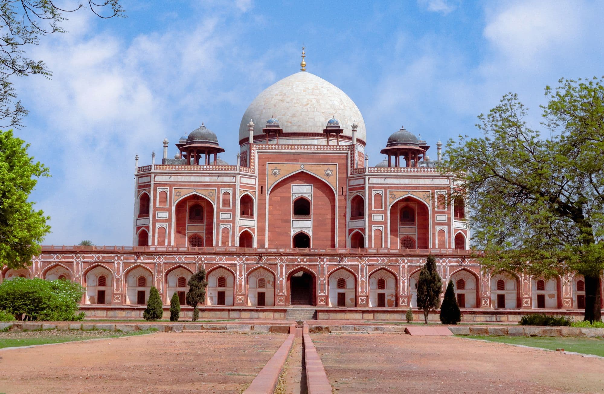Humayun's Tomb in Delhi, a red sandstone and white marble Mughal mausoleum with a white dome, seen across its gardens.