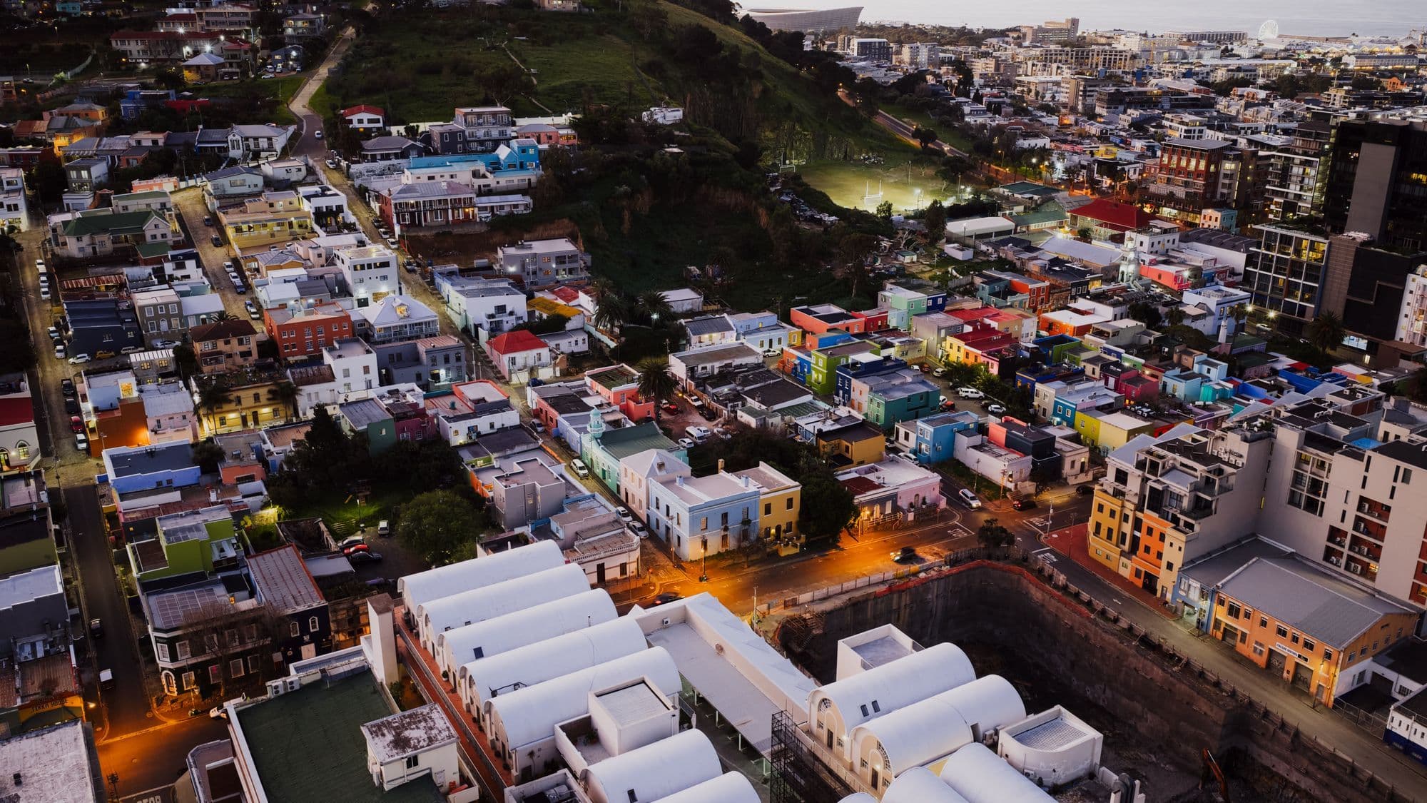 An aerial view at dusk over the brightly painted houses of Bo-Kaap climbing the slope of Signal Hill in Cape Town.