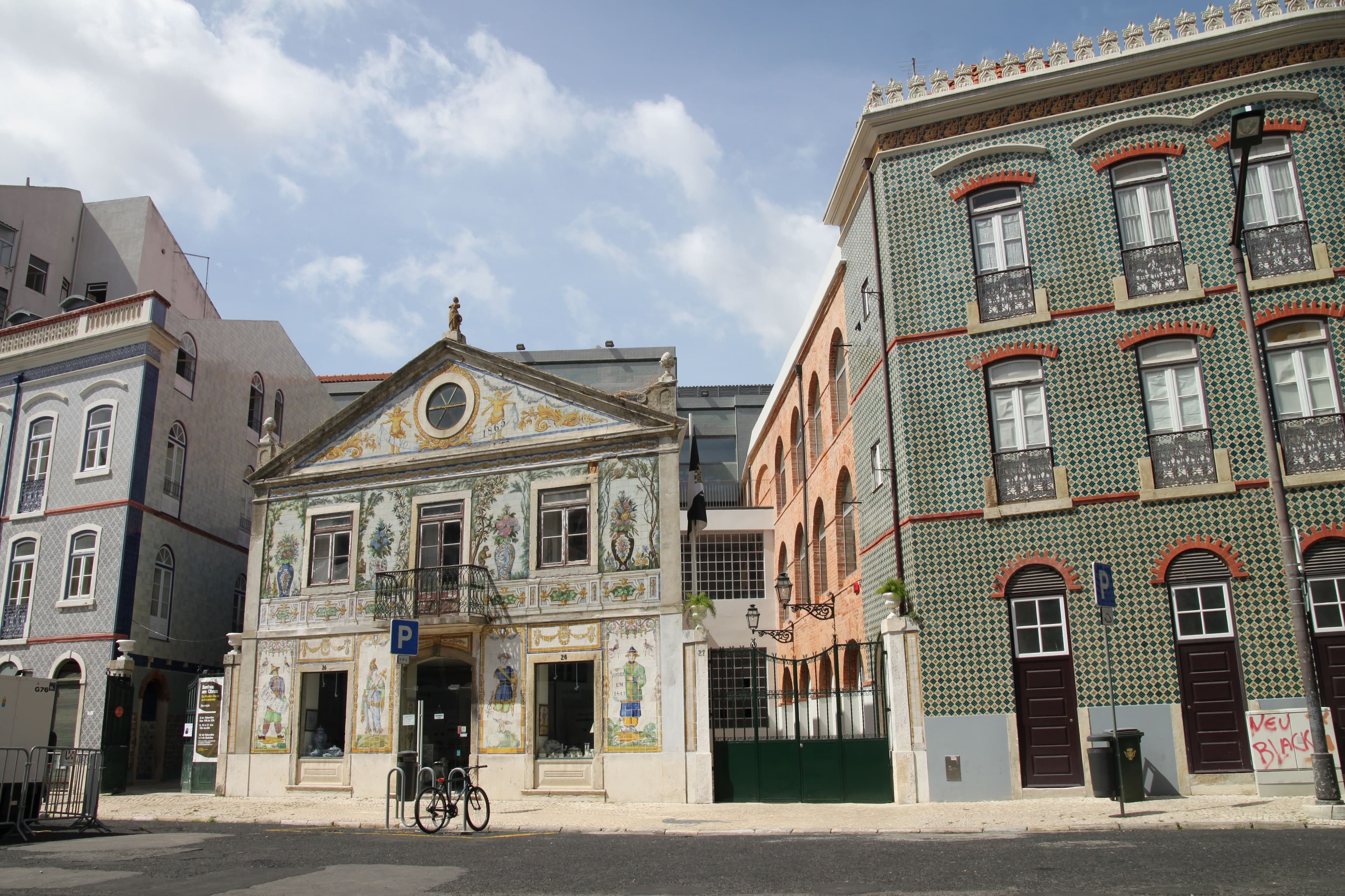 The tiled facade of the Viúva Lamego building on Largo do Intendente, next to a green-tiled apartment block.