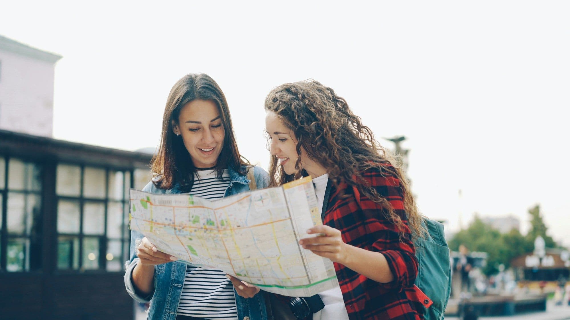 Two women studying a street map together outdoors.