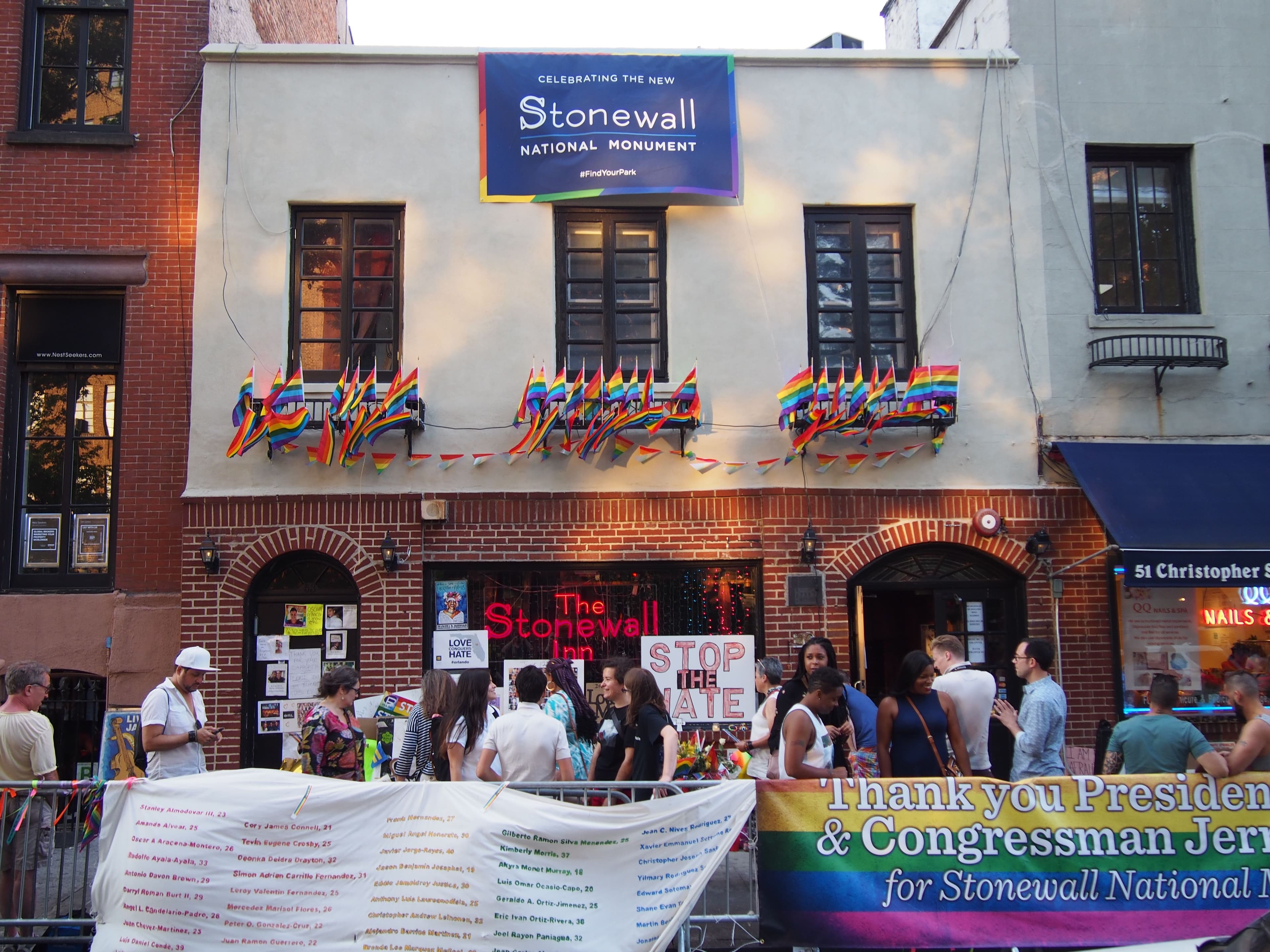 The brick facade of the Stonewall Inn on Christopher Street hung with rainbow flags during Pride weekend.