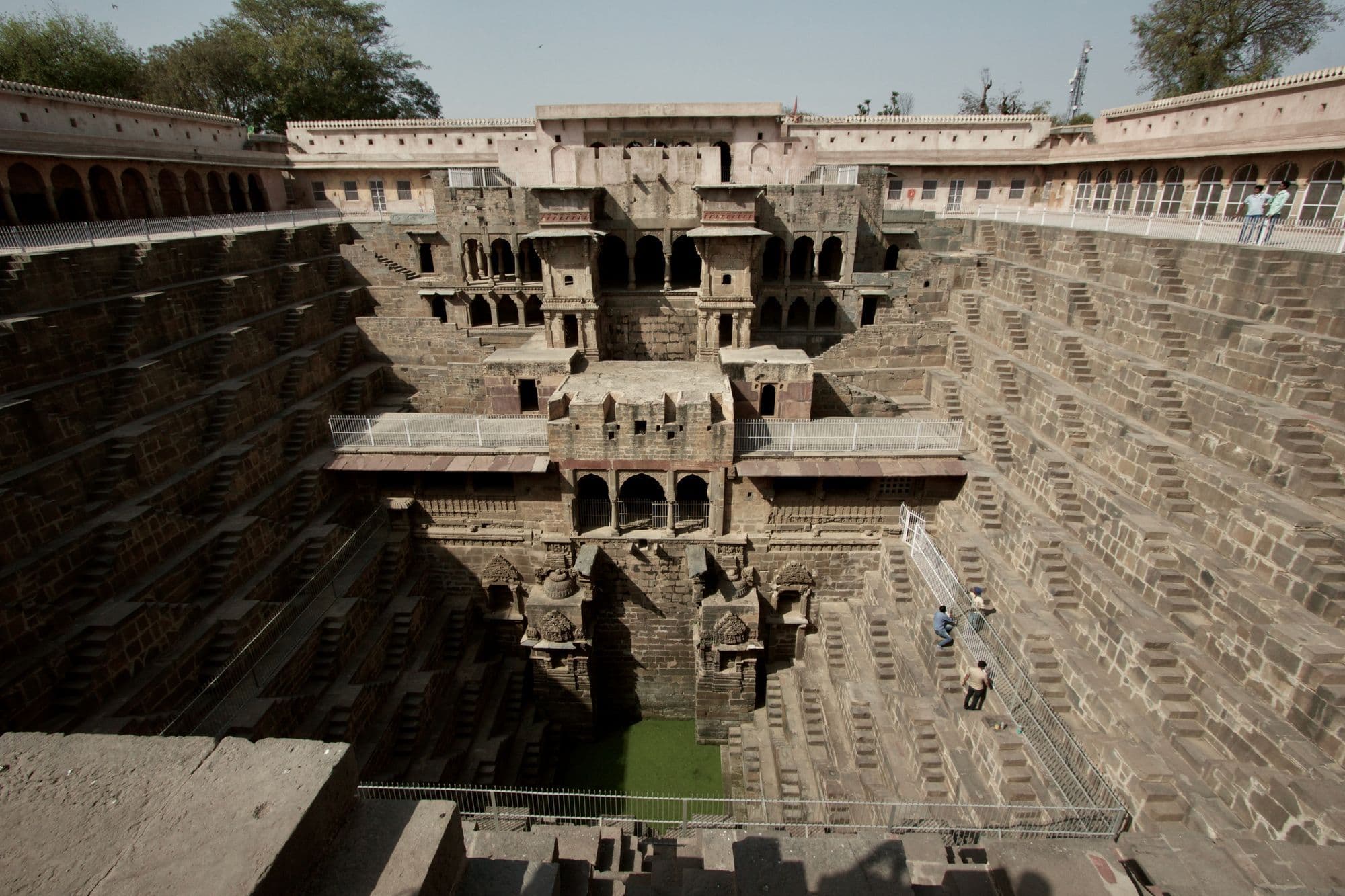 The geometric flights of stone steps descending into the Chand Baori stepwell at Abhaneri, with an arcaded pavilion at the top.