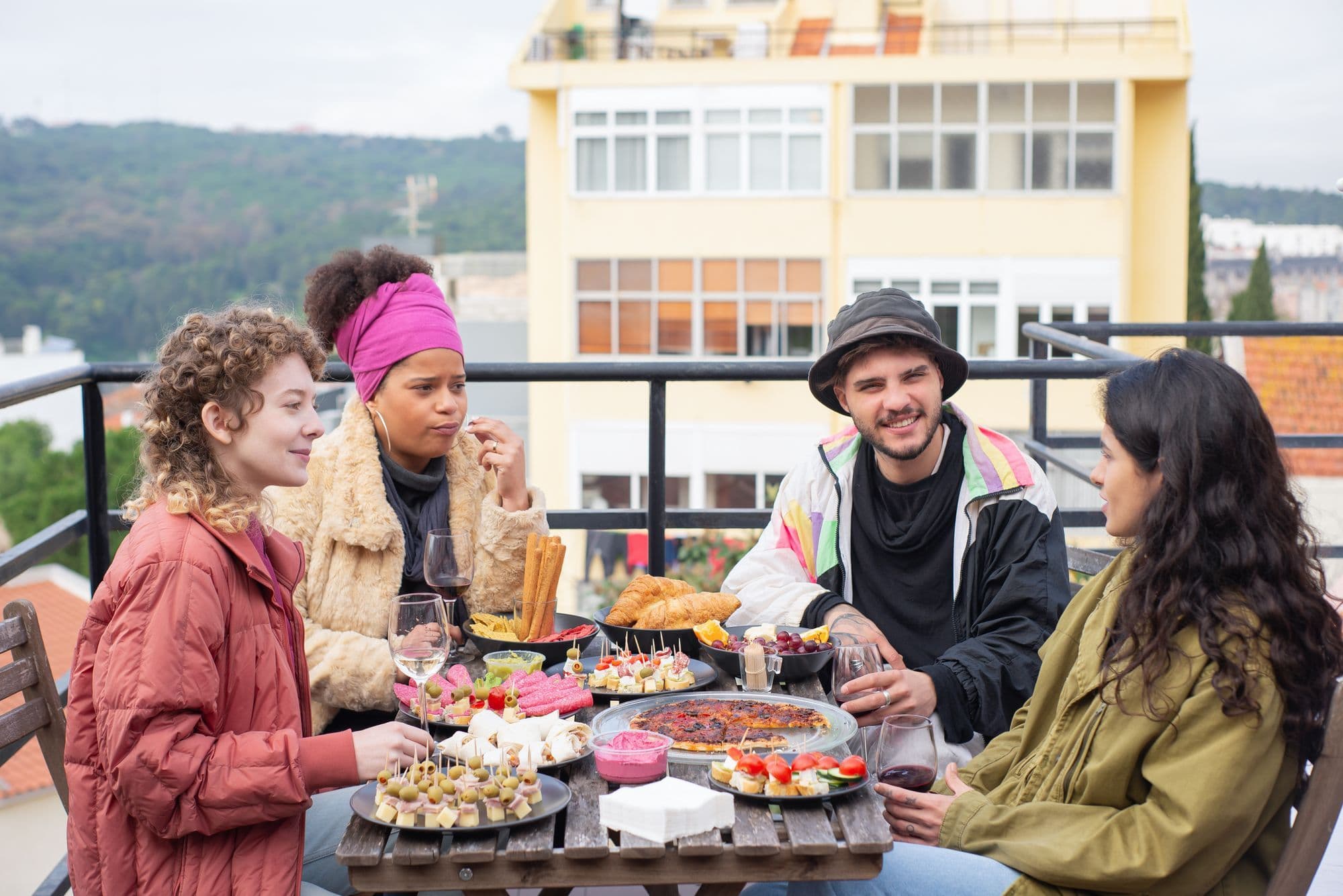 A small group sharing a meal at an outdoor restaurant table.