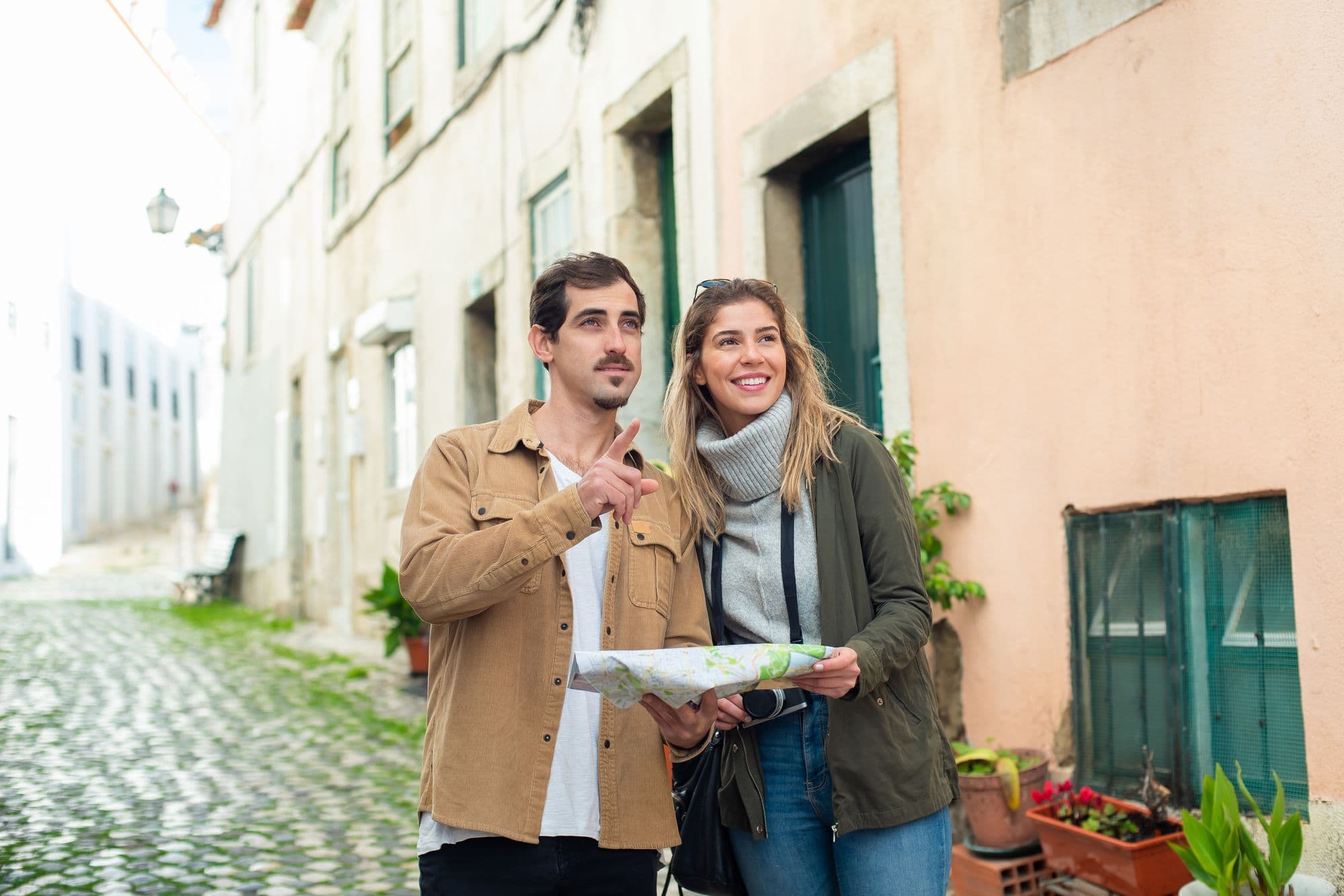 A couple reads a map together while exploring a historic city.